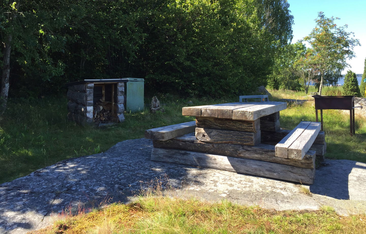 Rastplats med bord, bänkar, grill och vedförråd.