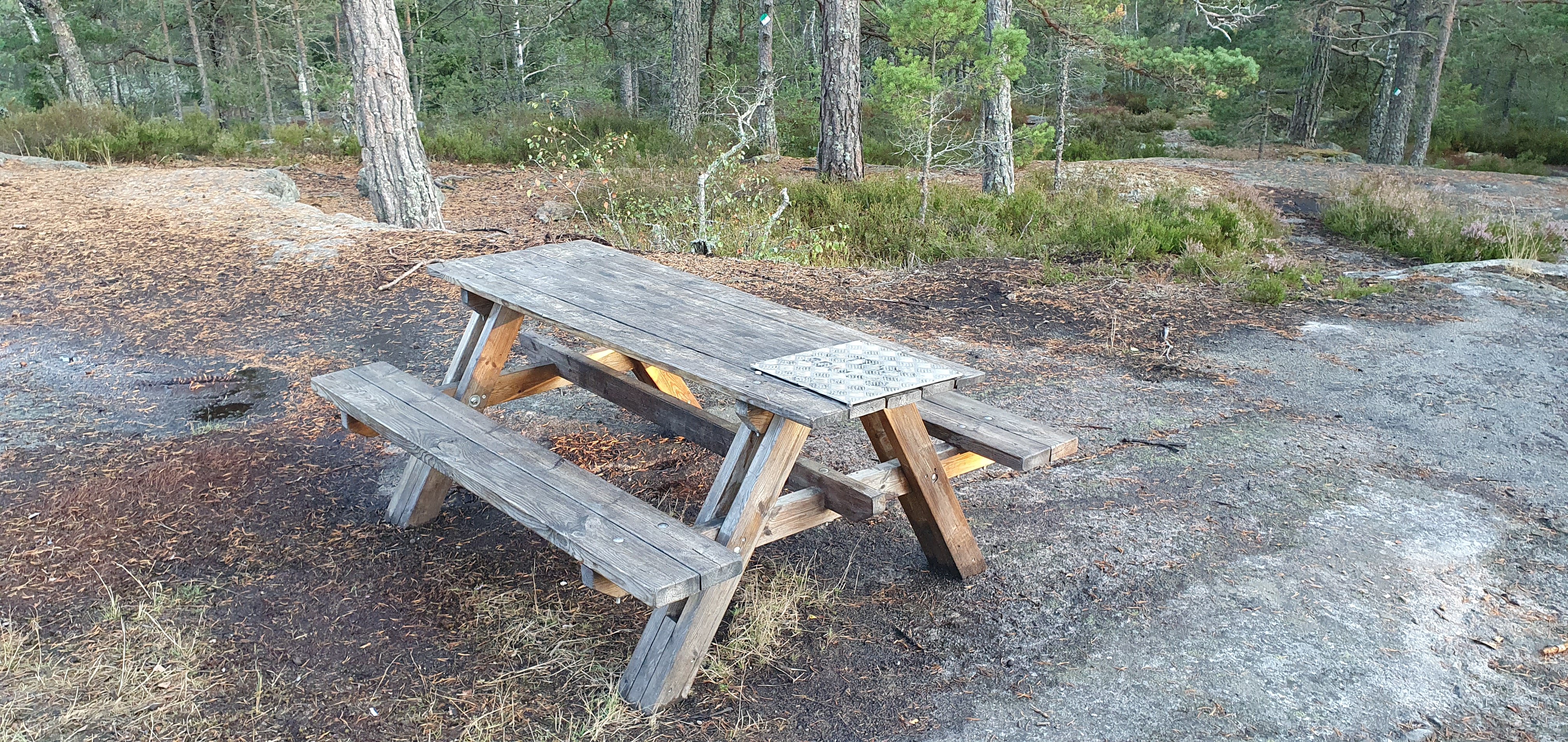 Ett bord med sittplatser står på berghällen.