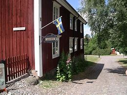 Röd träbyggnad i två våningsplan som inrymmer museum