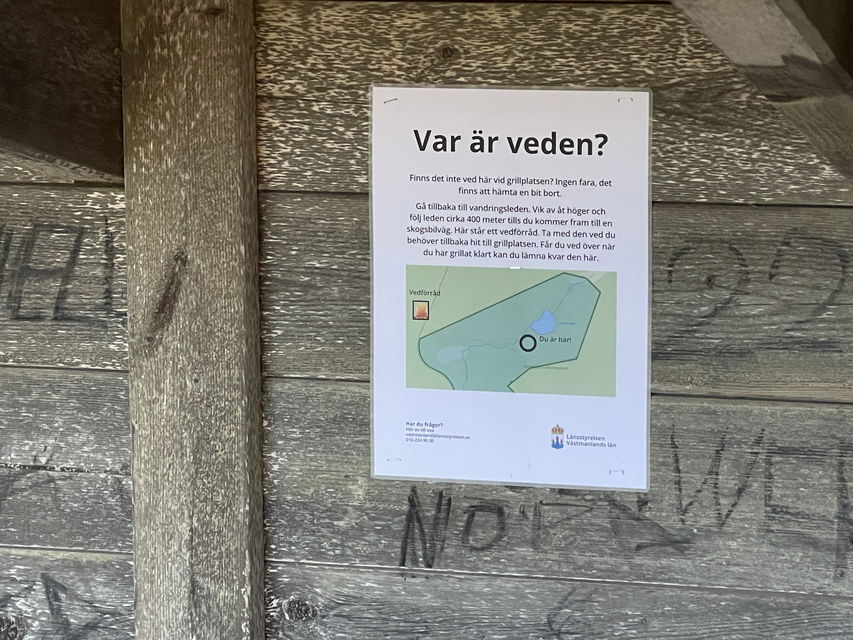 Informationsskylt om var vedförrådet är.