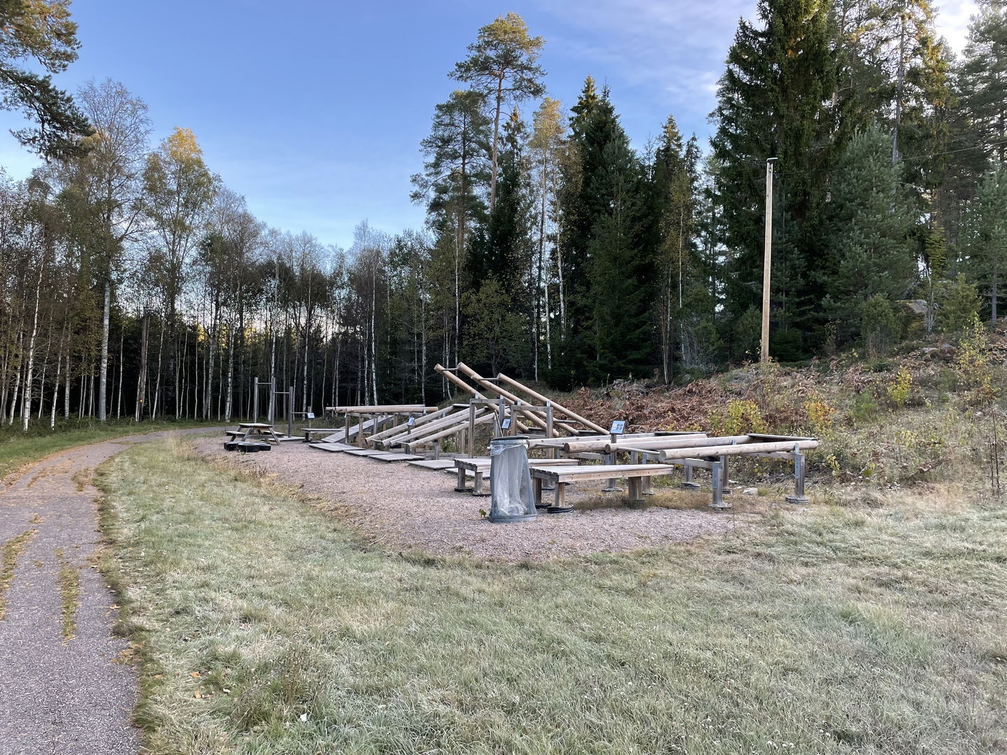 Utegym i trämaterial intill motionsspår i skogsmiljö