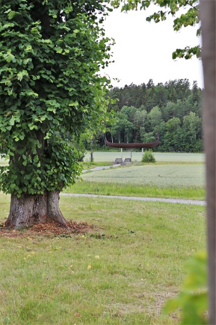 Utblick över Väsbyån som är resterna av den gamla farleden mellan Edssjön och Mälaren som fanns så sent som på vikingatiden. I bakgrunden skymtar skeppet Åfare som är placerad på den höjd där vattenytan låg över nuvarande mark då det begav sig.
