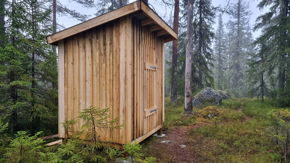En vedbod i granskog.