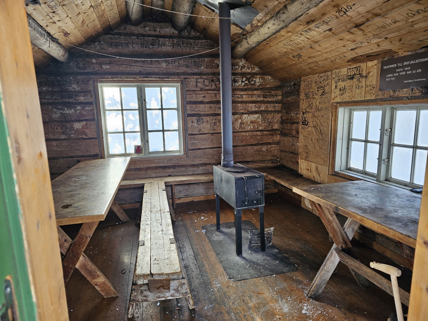En raststuga med bord och bänkar samt en kamin i.