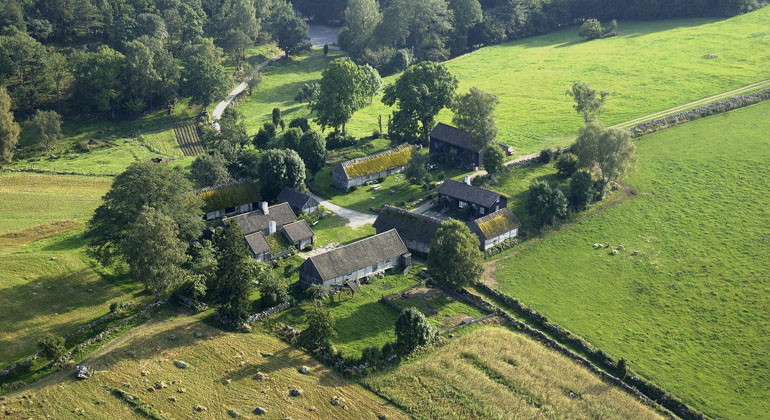 drönarbild över gård med hus och åker runt omkring