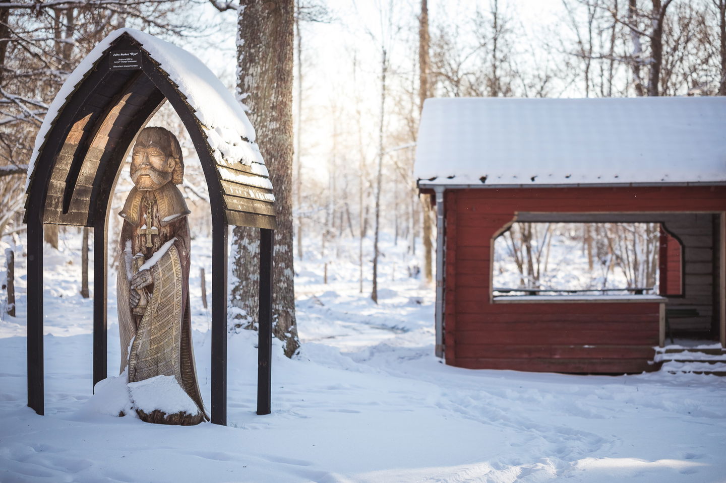 Röd stuga, staty och snö