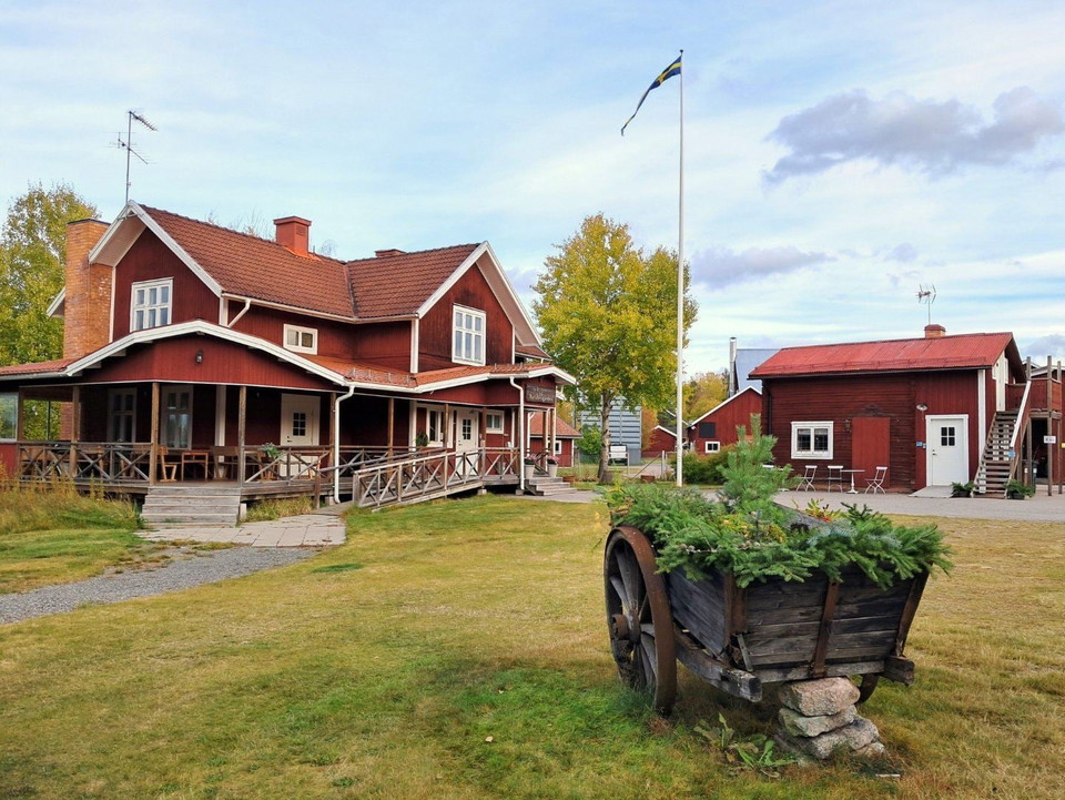 Ett rött hus med en vagn framför.