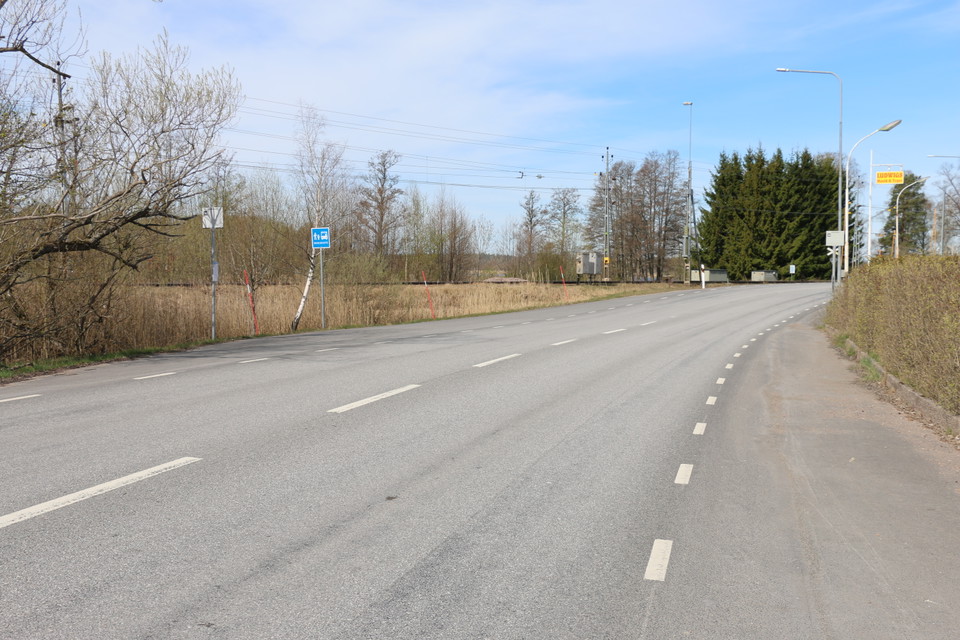 Busshållplats med hållplatsskylt efter landsvägen.