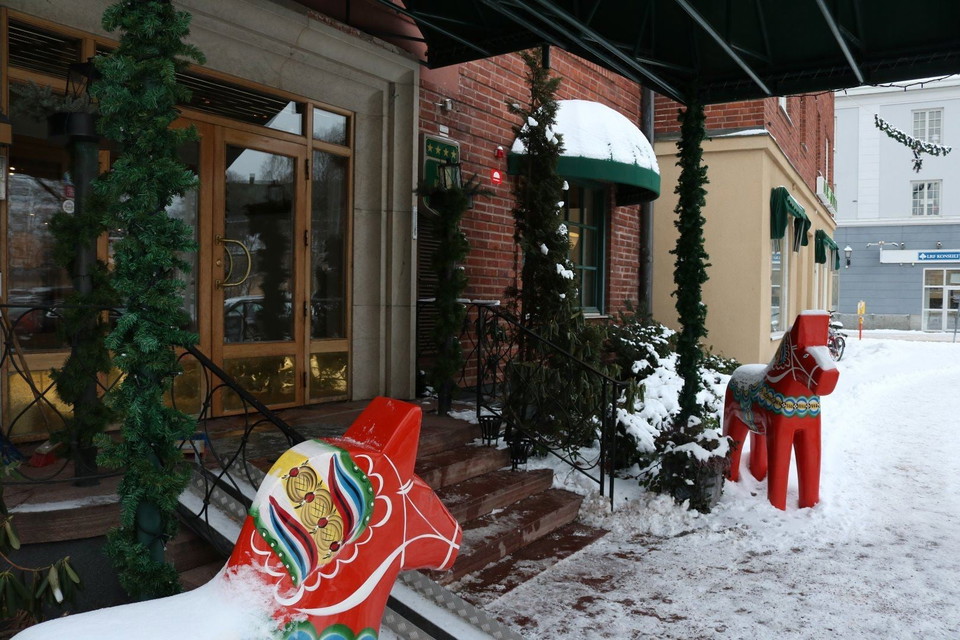 En staty av en röd häst framför en byggnad.