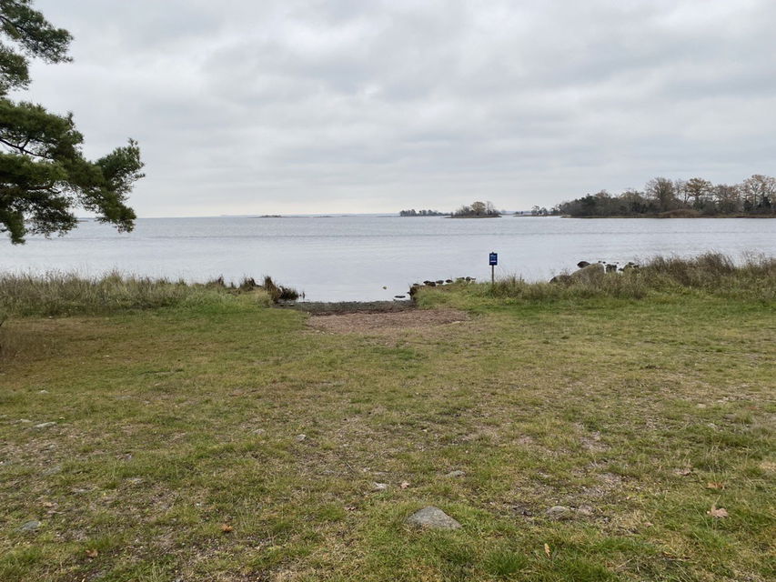 Liten sandstrand och gräsyta