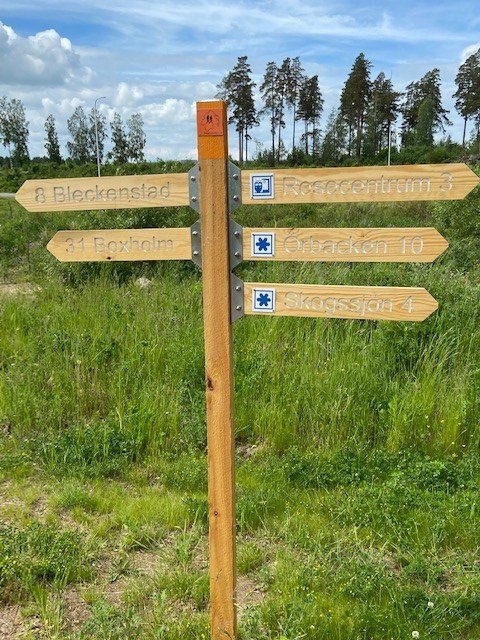 Vägvisningsskyltar för Östgötaleden mot Bleckenstad och mot Skogssjön med flera platser