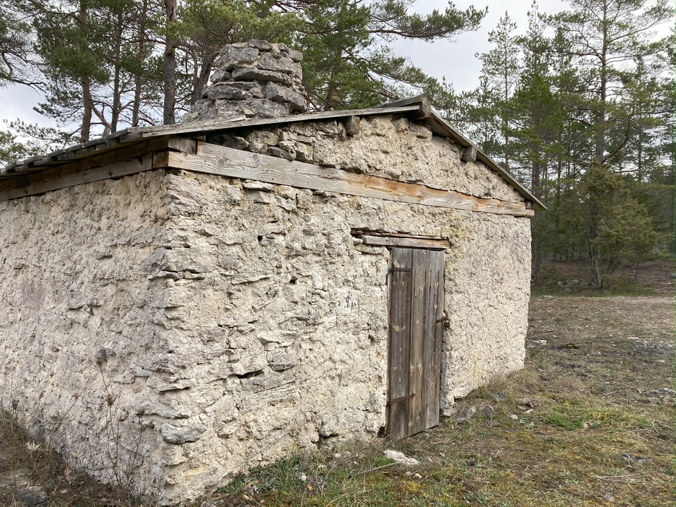 Ett gammalt stenhus i skogsmiljö. Kallmurat.