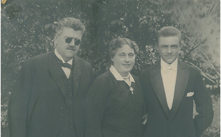 Gustaf, Julia och Salomon står i uppställda för fotografering, med finkläder på. Gustaf och Salomon har kostym. De står utomhus med en buske i bakgrunden.