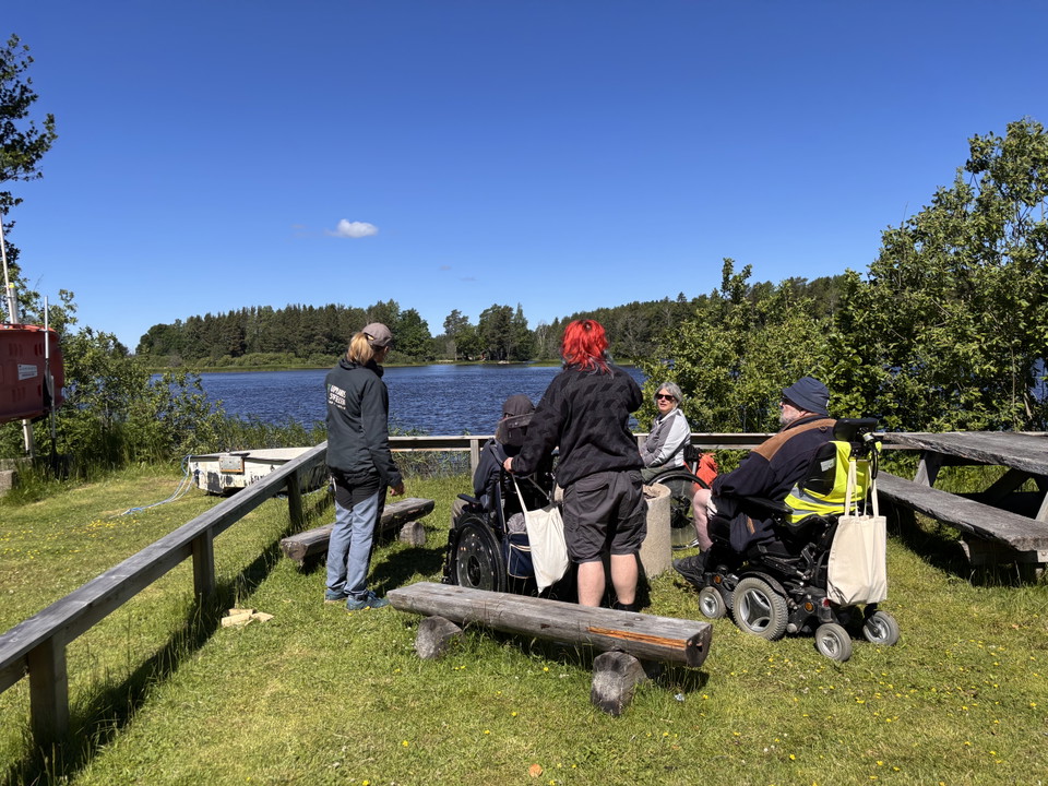 En grupp människor vid en eldstad precis vid vattnet.