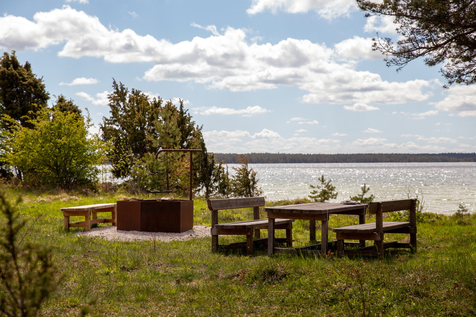 Grillplats och bänkbord på gräs vid sjö