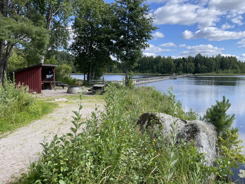 Bild på bänkbord, eldstad och ett vindskydd.