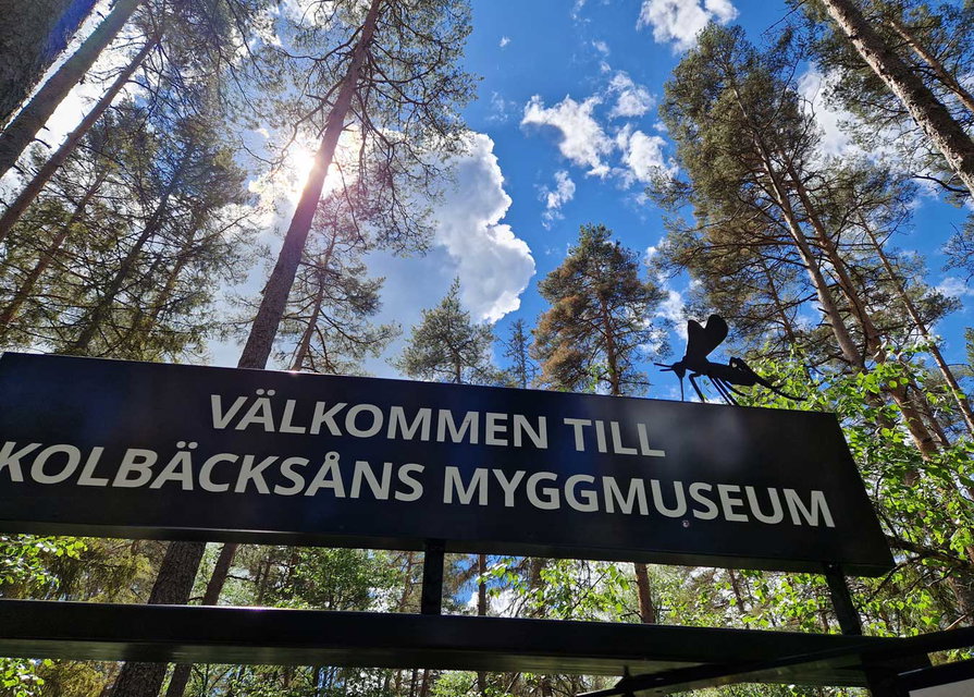 Entréskylt där det står "Välkommen till Kolbäcksåns myggmuseum"