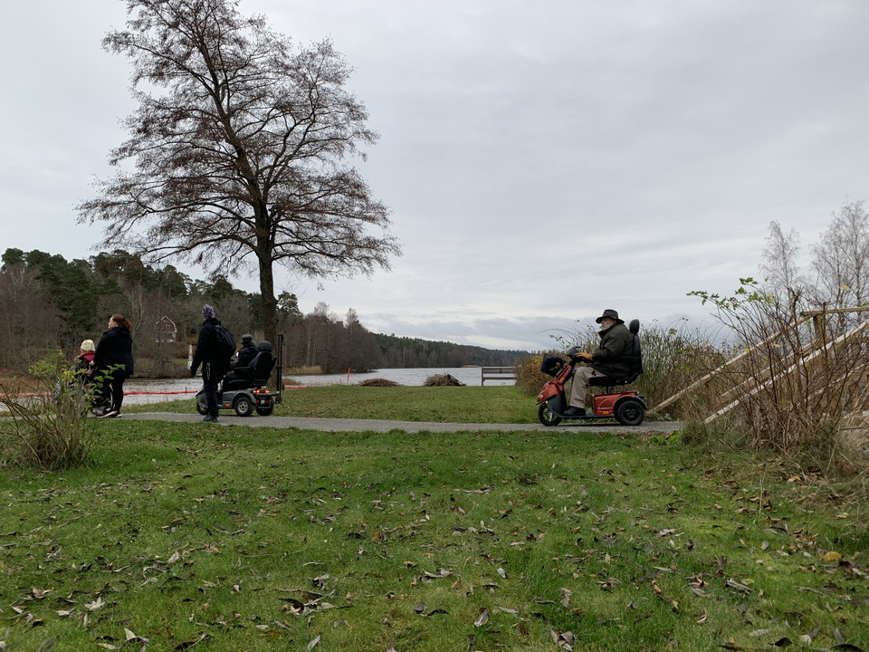 Några personer i rullstol med Ekoln i bakgrunden