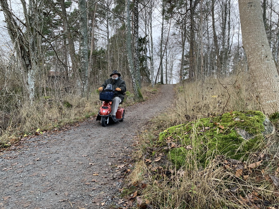 Man i elrullstol påväg nedför brant backe